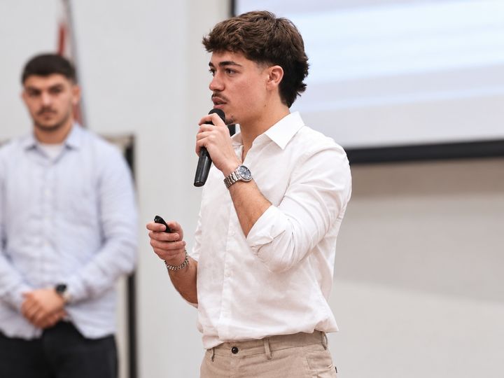 João Alves presenting technical work with a microphone